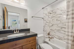 Full bathroom featuring vanity, toilet, and shower / tub combo