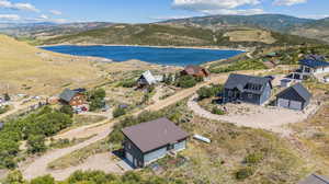 Birds eye view of property with a water and mountain view