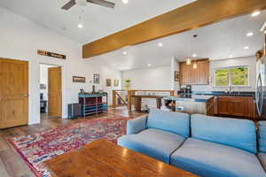 Living room featuring ceiling fan, sink, high vaulted ceiling, and light hardwood / wood-style floors