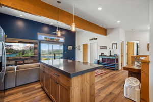 Kitchen featuring lofted ceiling with beams, hardwood / wood-style flooring, decorative light fixtures, and ceiling fan