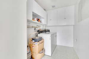 Laundry area featuring cabinets and separate washer and dryer