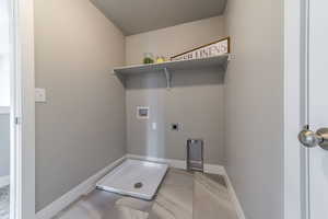 Washroom with hookup for a washing machine, light tile patterned flooring, and electric dryer hookup