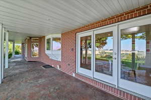 Covered back patio off of the kitchen with textured concrete floor design.