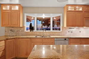 A twilight photo featuring a window above the kitchen sink captures a serene and evocative scene that highlights both the interior design and the changing light outside.