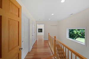 Hallway with closets and railing