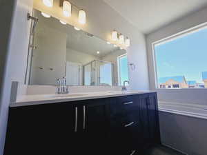 Bathroom with vanity, plus walk in shower, and a textured ceiling