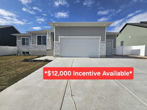 View of front of home with a garage and a front lawn