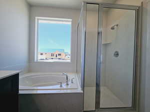 Bathroom with a healthy amount of sunlight, vanity, and plus walk in shower