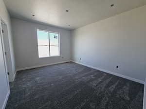 Carpeted empty room featuring a textured ceiling