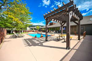 View of pool with a patio and a pergola