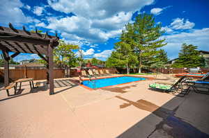 View of pool with a pergola and a patio area