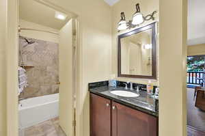 Bathroom featuring vanity and tiled shower / bath