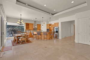 Dining area featuring a chandelier, recessed lighting, a raised ceiling, and visible vents