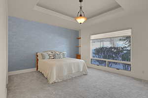 Carpeted bedroom featuring a raised ceiling, visible vents, baseboards, and wallpapered walls