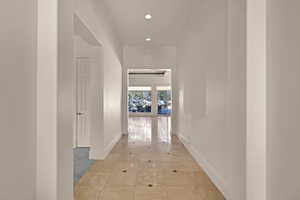 Hall featuring recessed lighting, baseboards, and light tile patterned floors