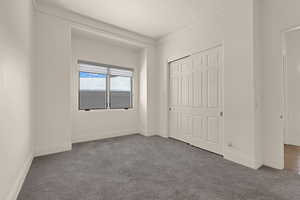 Unfurnished bedroom featuring a closet, carpet flooring, and baseboards