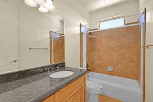 Bathroom with toilet, shower / washtub combination, and vanity