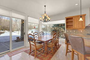 Dining room featuring light tile patterned floors, visible vents, a notable chandelier, and recessed lighting