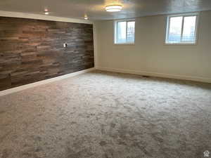 Spare room with a textured ceiling, a healthy amount of sunlight, and carpet flooring