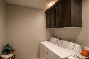 Washroom featuring cabinets and separate washer and dryer