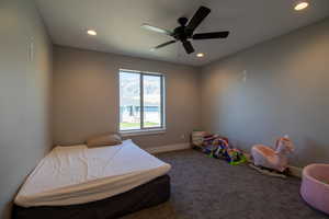 Carpeted bedroom featuring ceiling fan