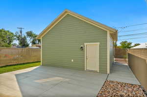 View of the garage with a door to the patio and home