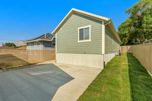 Rear view of the property featuring a lawn and patio in between the home and garage