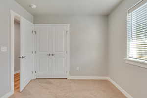 Unfurnished room with light carpet and a healthy amount of sunlight