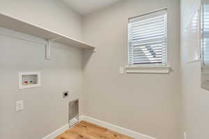 Laundry area with washer hookup, light wood-type flooring, and electric dryer hookup