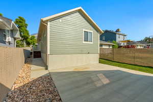 Rear view of property featuring a patio area off of the garage with stairs to the home