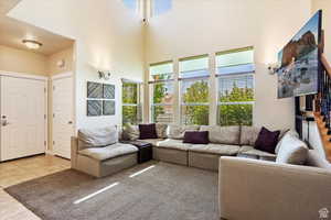 Tiled living room featuring plenty of natural light and a high ceiling