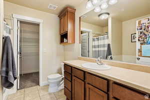 Bathroom with vanity, toilet, and tile patterned floors