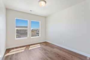 Empty room with light hardwood / wood-style floors