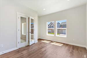 Unfurnished bedroom with wood-type flooring and french doors