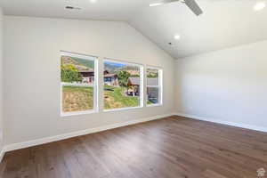 Empty room featuring vaulted ceiling, hardwood / wood-style floors, and ceiling fan