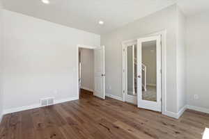 Empty room with french doors and hardwood / wood-style floors