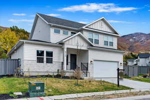 View of front of home featuring a front lawn, a garage, and a mountain view