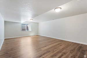 Interior space with a textured ceiling and hardwood / wood-style floors