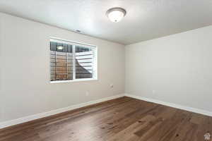 Spare room featuring hardwood / wood-style flooring and a textured ceiling