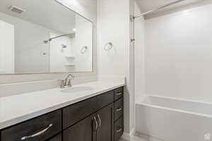 Bathroom featuring tile patterned flooring, vanity, and bathing tub / shower combination