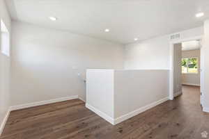 Unfurnished room with dark wood-type flooring