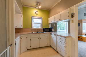 Kitchen featuring plenty of natural light, dishwasher, and white cabinets