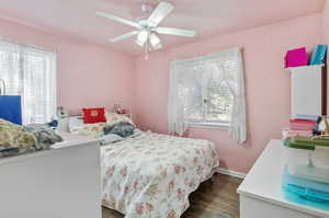 Bedroom with dark wood-type flooring and ceiling fan