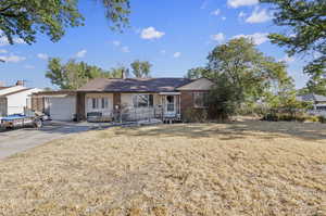 Single story home featuring a front lawn and a garage