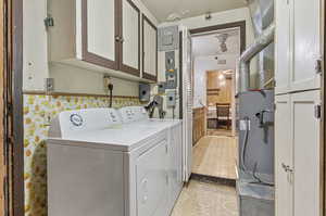 Washroom with cabinets, separate washer and dryer, and light tile patterned floors