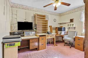 Carpeted home office with a textured ceiling and ceiling fan