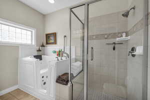 Bathroom with tile patterned flooring and plus walk in shower