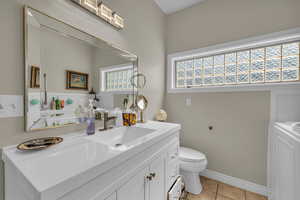 Bathroom featuring vanity, toilet, and tile patterned flooring