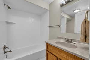 Bathroom with tile patterned floors,  shower combination, and vanity