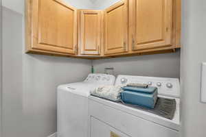 Washroom with cabinets and independent washer and dryer